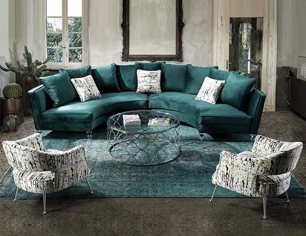 Ghế sofa góc tròn mềm mại, bọc vải nhung mượt mà, màu xanh cổ vịt sang trọng, quý phái, hoàng gia, đem lại cảm giác êm ái cho người ngồi. Đây là một món đồ nội thất lý tưởng cho những căn phòng khách thiết kế kiểu châu Âu