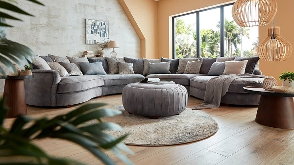 Mẫu sofa góc tròn này gây ấn tượng với người nhìn bởi gối tựa vải ánh bạc phát ra thứ ánh sáng lấp lánh và những đường xếp ly tinh tế, được cắt, khâu tỉ mỉ bằng tay chạy góc mép trong phần lưng. Kết hợp với đó là lớp vải nhung màu xám êm mịn, nhã nhặn mang lại vẻ đẹp sang trọng và sự thoải mái, dễ chịu