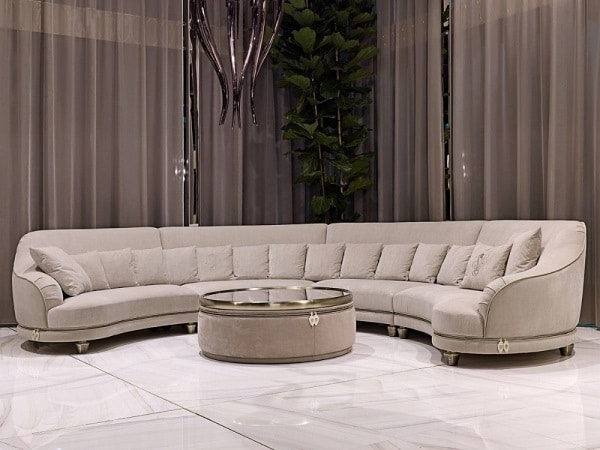 Ghế sofa góc tròn này có khung bằng ván đặc và gỗ ép chịu lực tốt, tựa lưng định hình cong cong giúp ôm trọn lưng người ngồi, vải bọc màu ghi sáng thanh nhã. Chân nhôm đúc khắc phù điêu hình da cá sấu tinh xảo kết hợp dây kéo bằng đồng, thanh trượt bằng da thêu logo trang trí cạnh, tay vịn, dưới đế sang trọng