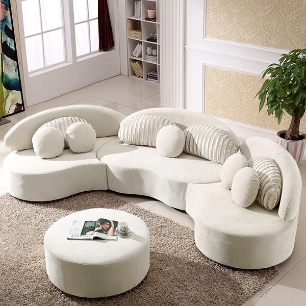 Mẫu sofa góc tròn này gây ấn tượng với mặt lưng cong mềm mại, phân chia thành nhiều mảng khối khác nhau như hình cánh hoa kết hợp với gối tựa hình bán nguyệt xếp ly đẹp mắt và gối ôm tròn nhỏ xinh, giàu sức hút. Toàn bộ ghế được bọc bằng vải nhung màu be mang vẻ đẹp dịu dàng, thanh lịch và cảm giác êm ái cho người dùng