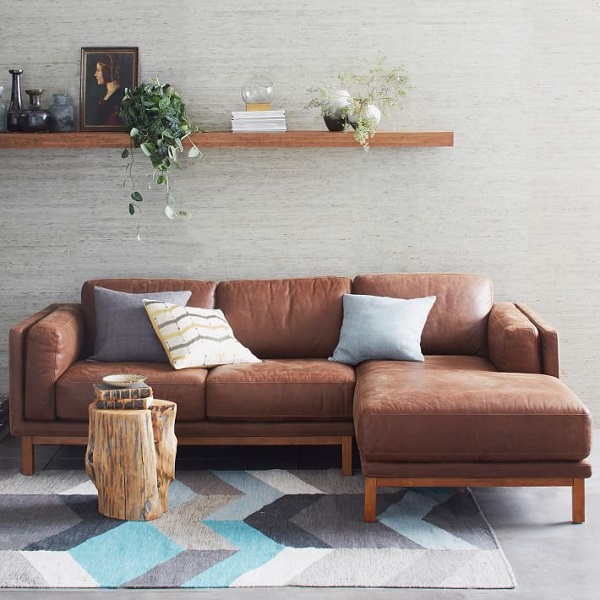 Để tăng sự tươi mới mà vẫn đảm bảo sự hài hòa và thân thiện cho sofa góc da nâu nơi phòng khách nhỏ, bạn có thể trang trí thêm một vài chiếc gối vải màu sắc trang nhã như thế này